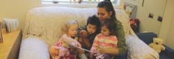 Teacher reading a children's book to three toddlers