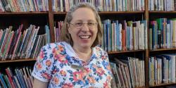 Betsy Cohen in front of a full bookcase