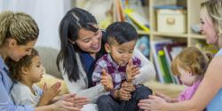 a group of toddlers and parents clapping together