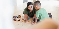 an adult playing with a child on the floor