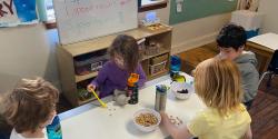 children using food to learn math on a table
