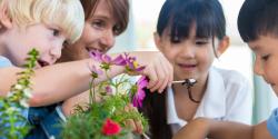 children observing a worm in a garden