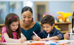 A teacher observing students drawing.