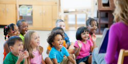 A group of children listening to their teacher.