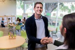 a parent shakes hands with a teacher