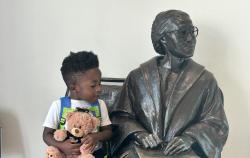 A child sitting with a statue