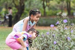 Two young children looking at a plant