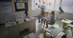 A teacher speaking with a family in a classroom