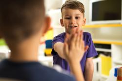 Two kids high fiving in school
