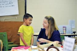 Teacher and student working with materials