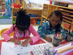 Two girls writing letters