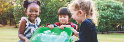 Three children with recycling bin