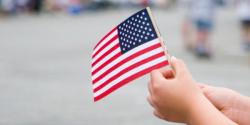 a child hand holding an american flag