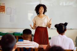 A teacher speaking at the front of the classroom