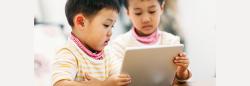 Two siblings watching tablet