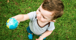 Toddler holding up a globe