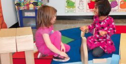 Two girls playing in block center