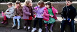 Children sitting on sidewalk