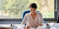 Early educator taking notes at her desk.