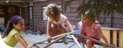 Three little girls playing together outside.