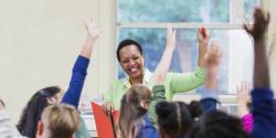 Teacher raising hand with students