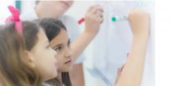 children writing on the white board