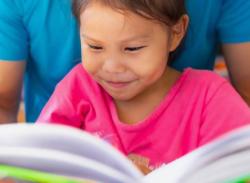 A young child reading a book.