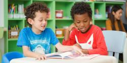 young children reading a book.