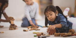 A child playing with blocks on the floor.