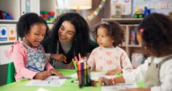 A teacher interacting with early childhood students in the classroom