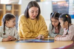 A teacher reading to a group of young children