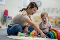 An early childhood educator teaching a child blocks