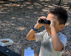 A boy looking through binoculars
