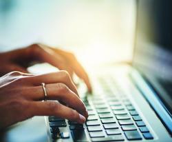 Fingers typing on a laptop