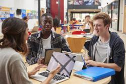 Diverse group of students are working in a library.