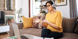 Woman on a couch talking on a computer