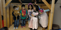 A group of young children dresses up for their stage production.