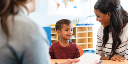 two adults talking with a young student