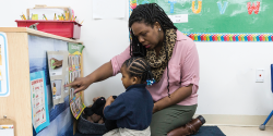 a teacher pointing to a diagram with a student