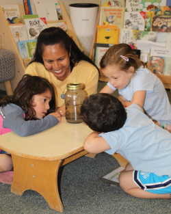 Feature Teacher Cecilia Fowler with students looking in a jar