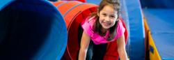 Young girl climbing out of a slide.