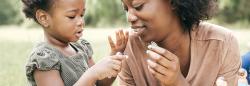 Young girl counting on her fingers with her mother.