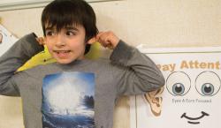 A young boy models "paying attention."