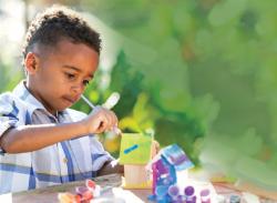 Child painting birdhouse