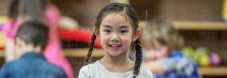 Asian girl in class smiling at camera