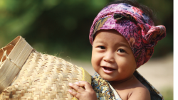 Young child in Indonesia with basket and colorful headscarf