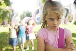 Unhappy girl with trio of girls behind her.