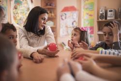 Children and teacher with red ball at table