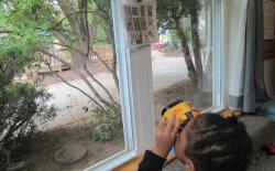 Child looking out window with binoculars