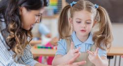 Teacher helping student count with fingers